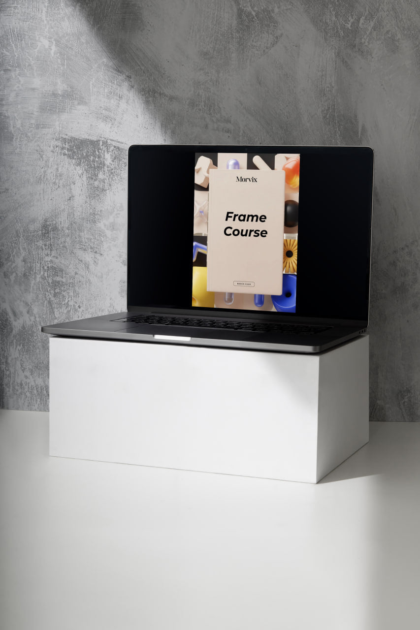 Laptop on a white stand with a gray concrete wall background